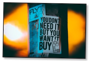 Picture of a flyer on a post communicating desire verses need which adds to global overconsumption. 